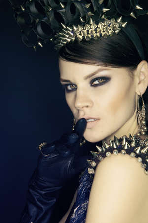 Woman in blue dress and headwear with spikes