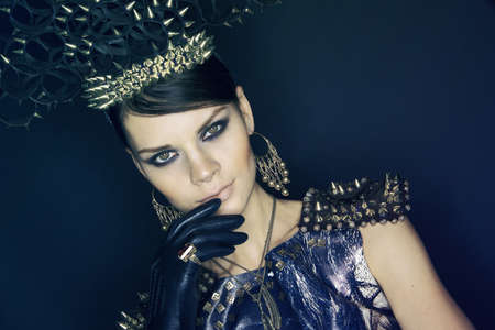 Woman in blue dress and headwear with spikesの写真素材