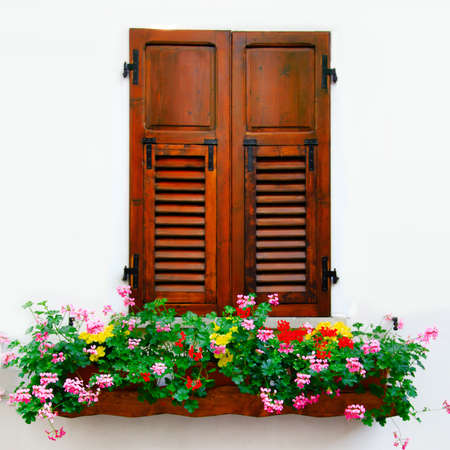 Old window with flowers, italian village.の写真素材