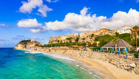 Turquoise sea, golden sand and houses in Tropea village, Calabria, Italyの写真素材