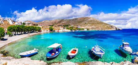 Turquoise sea, traditional boats and mountains, Vlichadia beach, Kalymnos island, Greece.