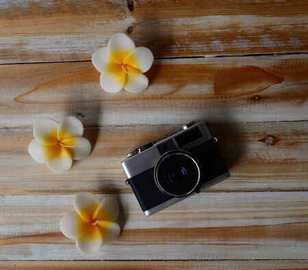 Vintage old camera with flower on the wooden