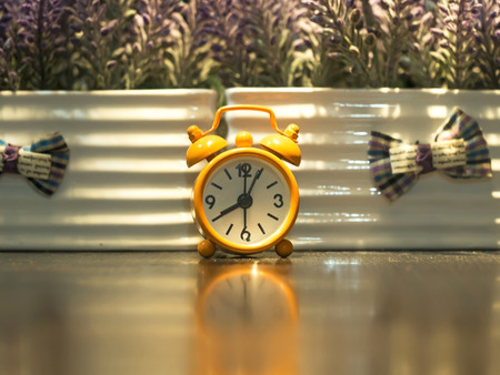 Old clock orange on the wooden table, saoft and select focusの写真素材