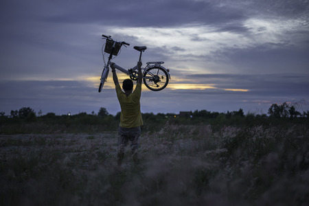 Hiker with bicycle watching sunset