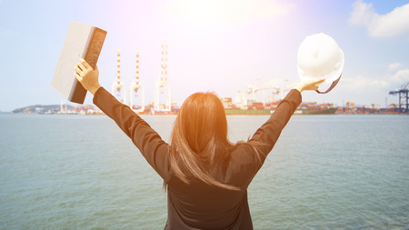 The women engineer working with container Cargo freight ship in shipyard at dusk for Logistic Import Export backgroundの写真素材