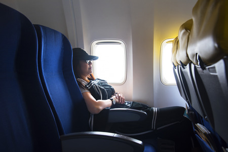 Women traveling by an airplane. Women sleep by aircraft window.の写真素材