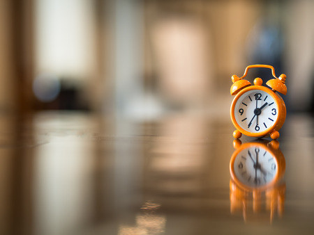 Old clock orange on the wooden table, soft and select focusの写真素材