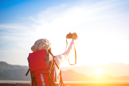 Hiker woman take a photo on the mountain, background blue sky, Thailand, select and soft focusの写真素材