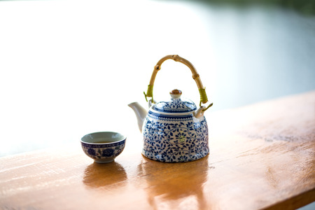 Teapot and cups on table in the sunriseの写真素材