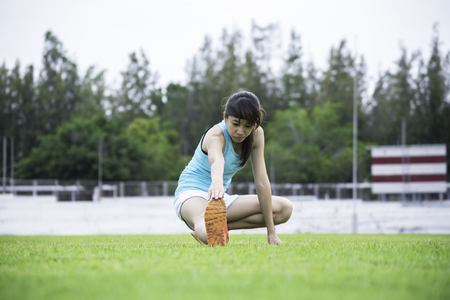 Young sportswoman stretching and preparing to runの写真素材