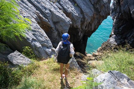Hiker woman look binoculars on the sea, background blue sky, Thailand,の写真素材