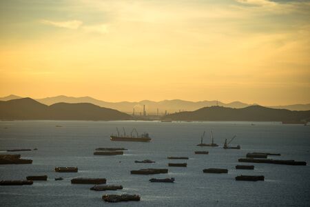 A cargo ship carrying goods between ports in the sunriseの写真素材
