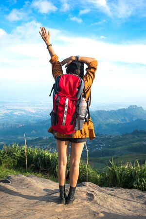 Hiker woman look binoculars on the mountain, background blue sky, Thailandの写真素材
