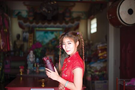 Chinese woman in traditional cheongsam in the new year in the Shrineの写真素材