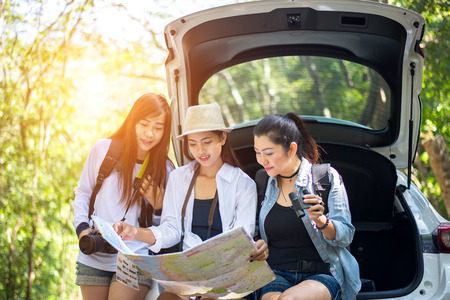 Group woman traveler sitting on hatchback car with forest backgroundの写真素材