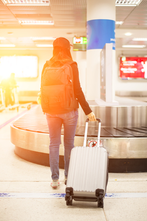 Traveler women waiting bag in the mpty baggage claim area at airportの写真素材