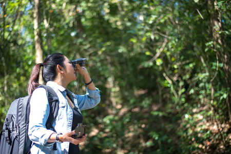 Traveler woman look binoculars on the forest, background forest Thailand, select and soft focusの写真素材