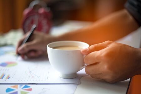 Close-up of business man holding cups of coffeeの写真素材