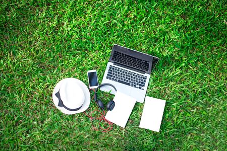 Enjoy listening music on the grass field of the park in the morning, greenery tone 2017の写真素材