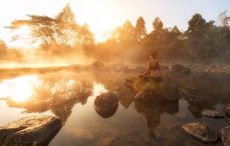 Beautiful Yoga woman in the morning at the hot spring park.の写真素材