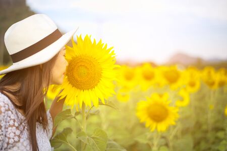 Women smells sunflower in natureの写真素材