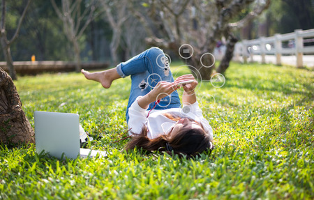 Women using mobile payments online shopping and icon customer network connection on screen, in the nature parkの写真素材