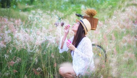 Woman blowing bubbles in meadow. travel and sunset, soft focusの写真素材