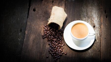 Coffee cup and coffee beans on tableの写真素材