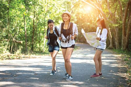 Group of beautiful young women walking in the forest, enjoying vacation, travel conceptの写真素材
