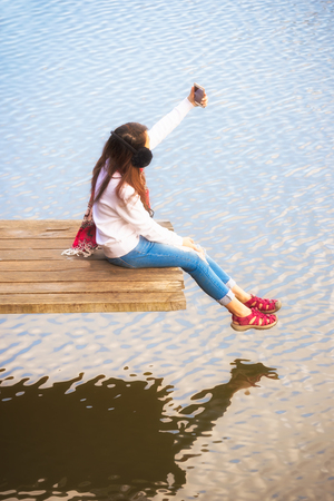 Woman relaxing and take a photo in summer sunshine sky outdoor. People freedom styleの写真素材