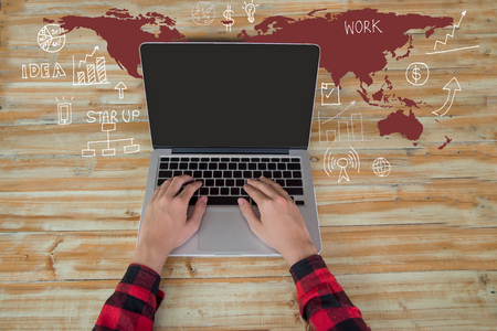 Man hand working on laptop computer keyboard with blank screen monitor with the map drawing charts and graphs business success strategy plan ideaの写真素材