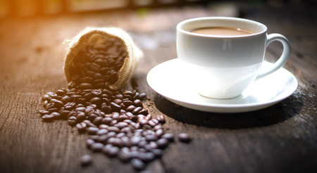 Coffee cup and coffee beans on tableの写真素材