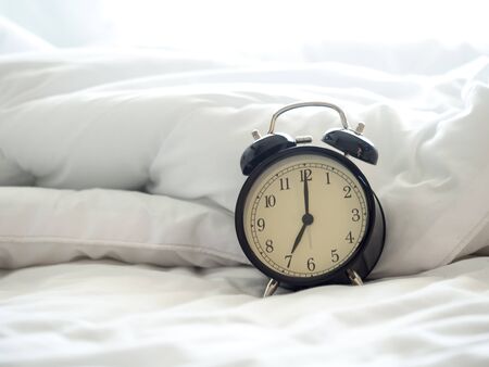 Alarm clock on bed in morning with sun light

の写真素材