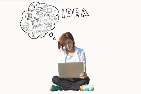 Young pretty lady with laptop in casual dreaming about futureの写真素材