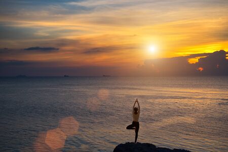 Meditation girl on the sea during sunset. Yoga silhouette. Fitness and healthy lifestyle.の写真素材