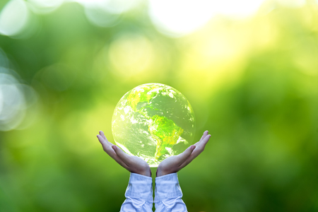 Holding a glowing earth globe in his hands. Earth image provided by Nasa.の写真素材