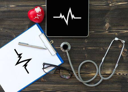 A medical stethoscope near a laptop on a wooden table, on whiteの写真素材
