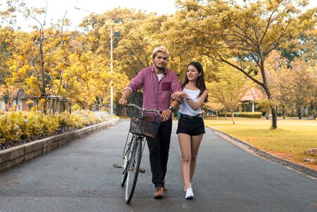 Happy couple riding bicycle in the park,copy space.の写真素材