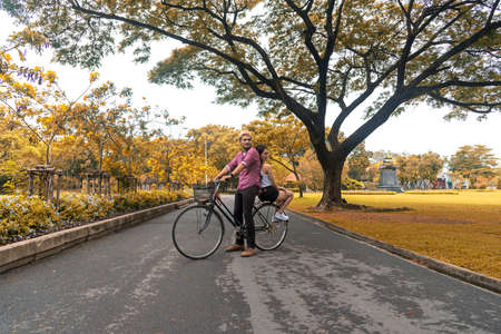 Happy couple riding bicycle in the park,copy space.の写真素材