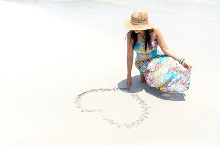 Woman On Beach Summer Vacation, Girl Draw Heart Shape Lying Sand Seaside Sea Ocean Holiday Travelの写真素材