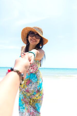 Smiling couple holding hands on the beachの写真素材