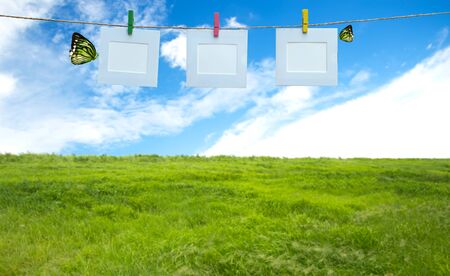Vacation photos hanging on a rope, blue sky backgroundの写真素材