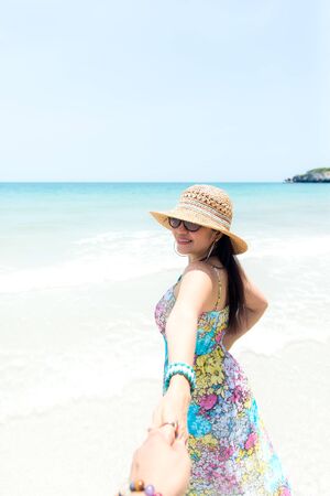 Smiling couple holding hands on the beachの写真素材