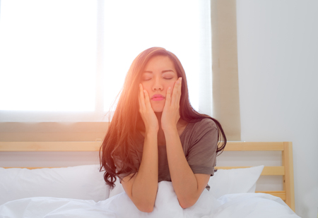 Young woman waking up in her bedの写真素材