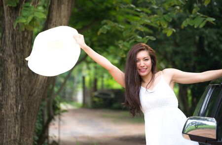 Woman in car road trip waving out the window smilingの写真素材