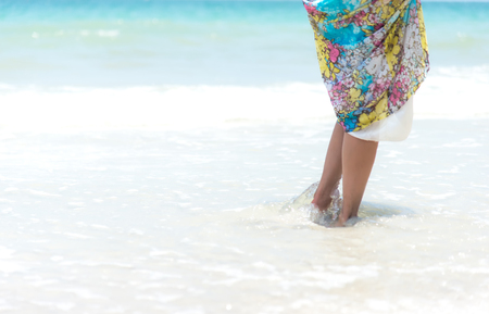 Woman walks towards the beautiful beachの写真素材