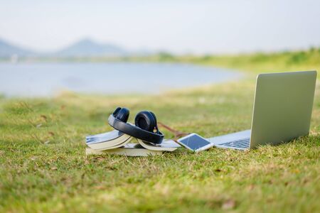Enjoy listening music on the grass field of the park in the morningの写真素材