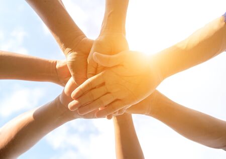 Hands of people team close up on blue sky backgroundの写真素材