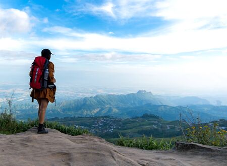 Hiker woman look binoculars on the mountain, background blue sky, Thailand, select and soft focusの写真素材