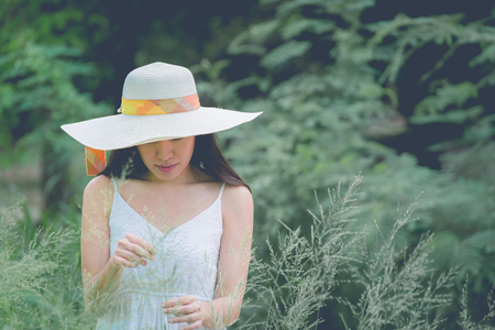 Portrait of happy and enjoying young woman on a meadow on a sunny summer day, vintage toneの写真素材